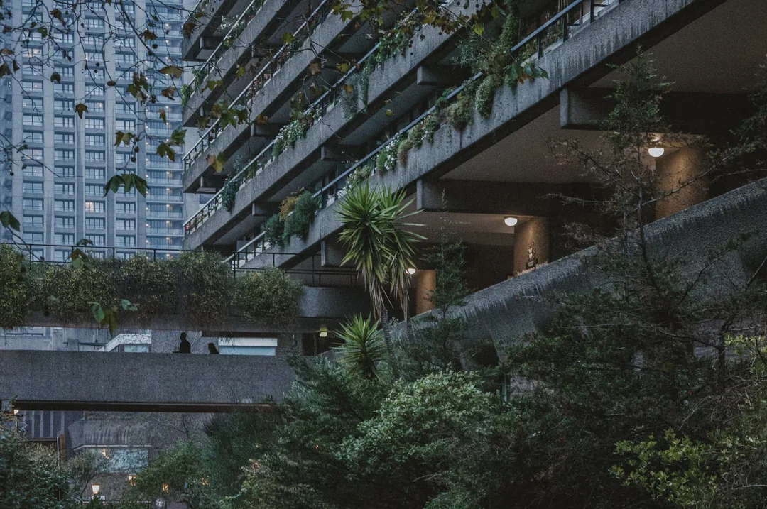 The Barbican Estate in London at dusk, planted balconies above a garden